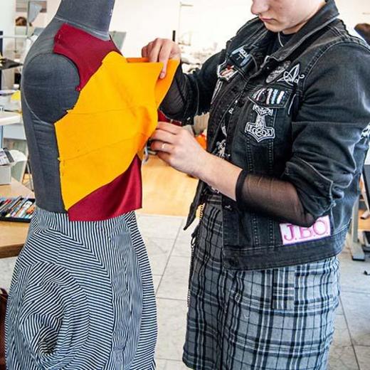 Schülerin steckt etwas an der Büste ab.