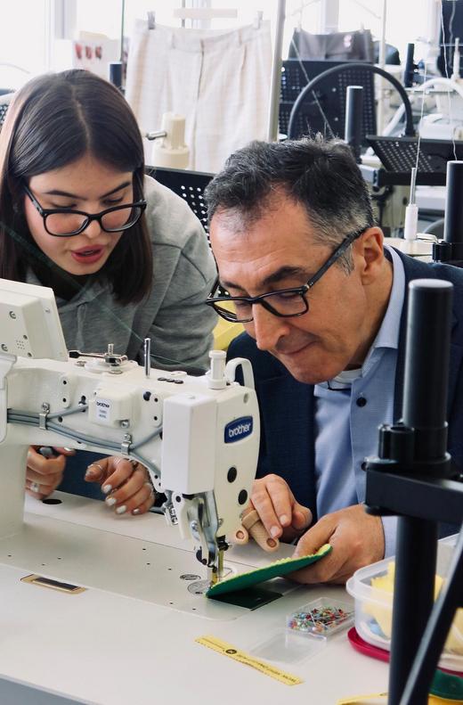 Cem Özdemir und eine Schülerin nähen