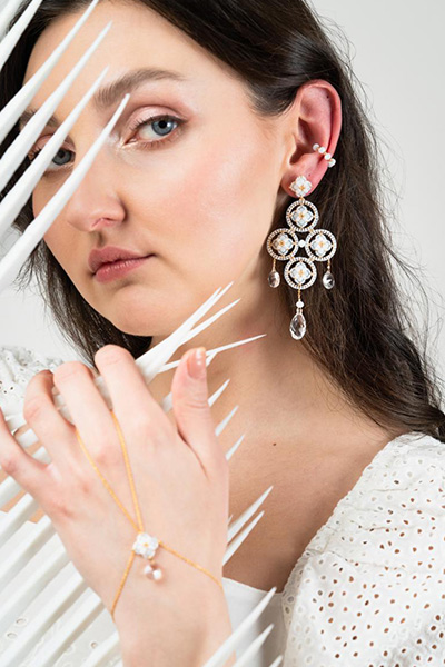 Frau präsentiert ihren Schmuck am Ohr und an der Hand