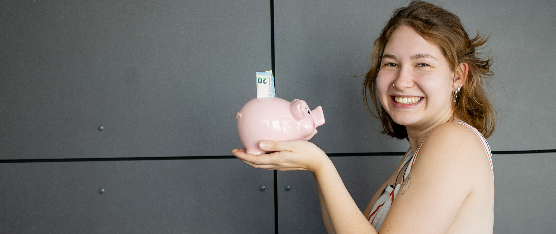 junge Frau mit einem Sparschwein in der Hand