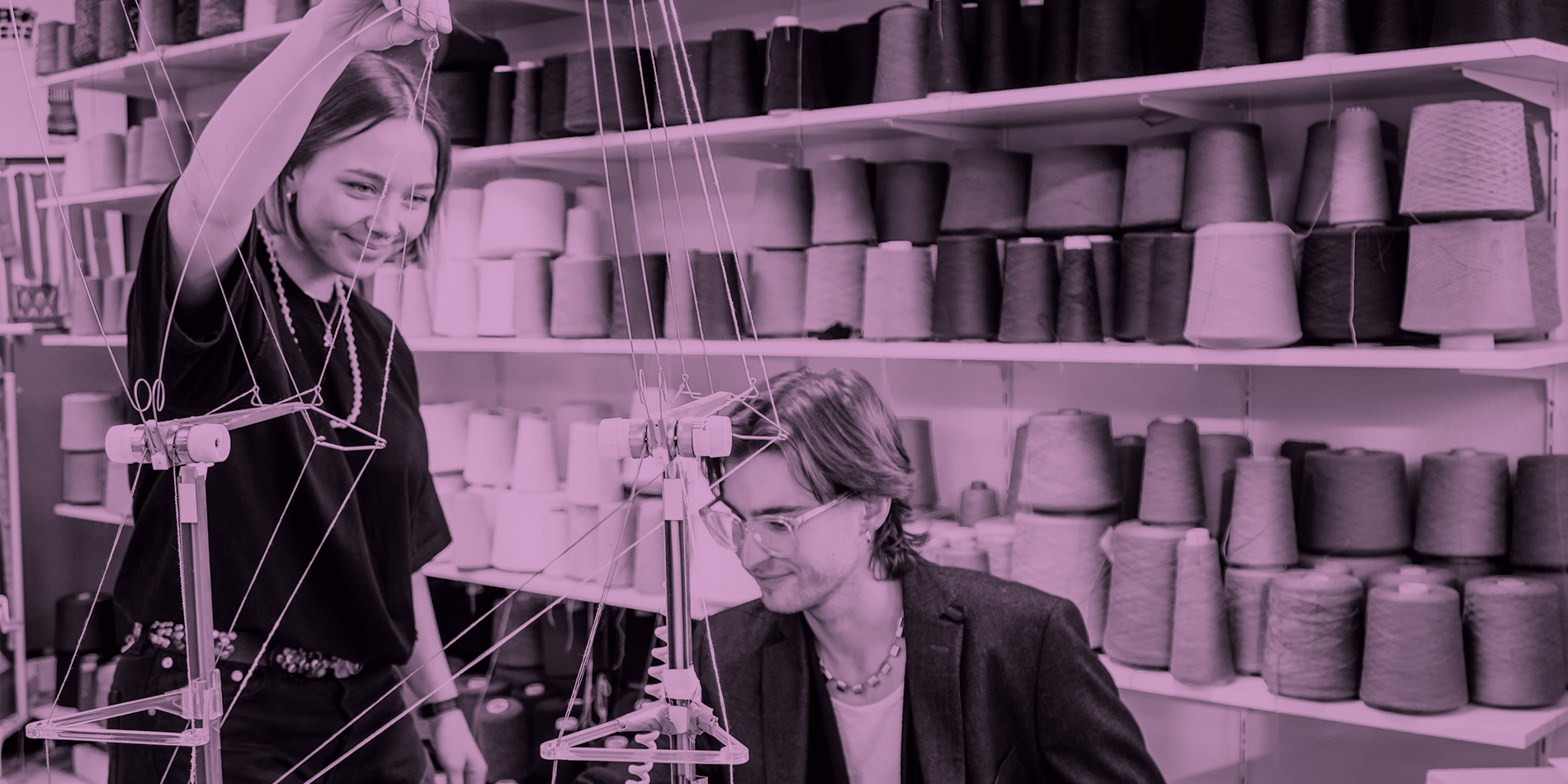 zwei Schüler die an einer Strickmaschine sitzen